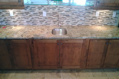 Inspiration for a mid-sized timeless u-shaped ceramic tile home bar remodel in Denver with an undermount sink, shaker cabinets, medium tone wood cabinets, granite countertops and beige backsplash