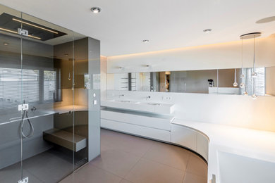 Geräumiges Modernes Badezimmer En Suite mit weißen Schränken, Einbaubadewanne, bodengleicher Dusche, beiger Wandfarbe, Keramikboden, Mineralwerkstoff-Waschtisch, beigem Boden, weißer Waschtischplatte, Doppelwaschbecken und schwebendem Waschtisch in Frankfurt am Main