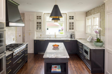 Klassische Küche in U-Form mit Einbauwaschbecken, weißen Schränken, Küchengeräten aus Edelstahl, dunklem Holzboden und Kücheninsel in Minneapolis