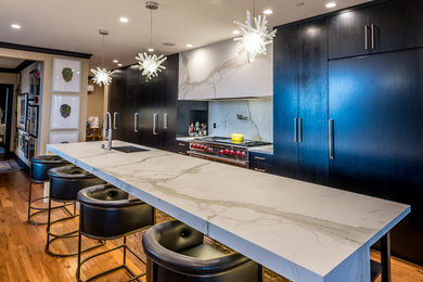 Eat-in kitchen - large contemporary l-shaped medium tone wood floor and brown floor eat-in kitchen idea in Milwaukee with an undermount sink, flat-panel cabinets, dark wood cabinets, marble countertops, white backsplash, stainless steel appliances and an island