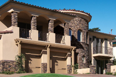 Example of a large tuscan beige two-story mixed siding flat roof design in Other