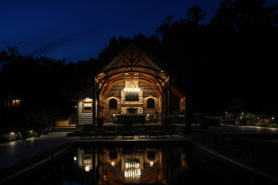 Example of a huge mountain style backyard stone and custom-shaped pool house design in DC Metro