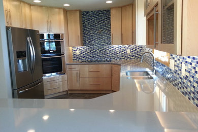Inspiration for a mid-sized transitional u-shaped vinyl floor kitchen remodel in Cedar Rapids with an undermount sink, flat-panel cabinets, light wood cabinets, quartzite countertops, blue backsplash, mosaic tile backsplash, stainless steel appliances and an island