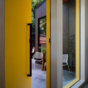 Contemporary ADU Entry with Yellow Door and Private Patio