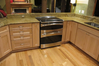 Eat-in kitchen - mid-sized light wood floor eat-in kitchen idea in Seattle with a drop-in sink, light wood cabinets, marble countertops and stainless steel appliances