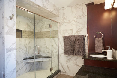 Inspiration for a mid-sized transitional 3/4 bathroom in Columbus with dark wood cabinets, an alcove shower, gray tile, white tile, porcelain tile, multi-coloured walls, porcelain floors, an undermount sink, granite benchtops and raised-panel cabinets.