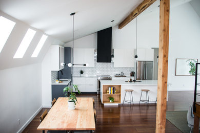 Large danish l-shaped medium tone wood floor and brown floor eat-in kitchen photo in Vancouver with an undermount sink, flat-panel cabinets, white cabinets, quartz countertops, white backsplash, porcelain backsplash, stainless steel appliances, an island and white countertops