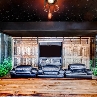 Large rustic enclosed home cinema in Denver with multi-coloured walls, a built-in media unit and carpet.