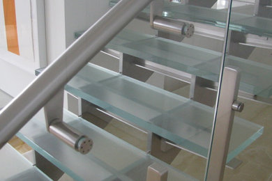 Imagen de escalera recta minimalista de tamaño medio sin contrahuella con escalones de vidrio