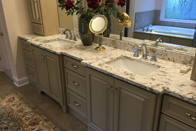 Inspiration for a mid-sized transitional master corner shower remodel in Atlanta with raised-panel cabinets, gray cabinets, gray walls, an undermount sink, granite countertops, a hinged shower door and gray countertops