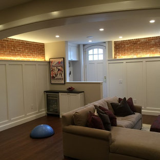 Design ideas for a medium sized traditional walk-out basement in Providence with white walls, bamboo flooring, a standard fireplace and a brick fireplace surround.