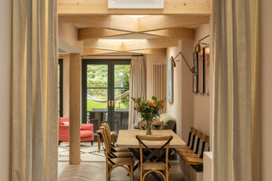 Photo of a medium sized classic kitchen/dining room in London with medium hardwood flooring and exposed beams.