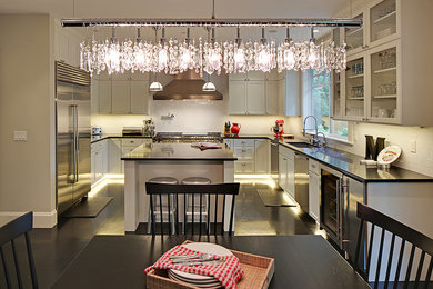 Eat-in kitchen - huge contemporary u-shaped dark wood floor and brown floor eat-in kitchen idea in Seattle with a single-bowl sink, quartzite countertops, white backsplash, ceramic backsplash, stainless steel appliances, black countertops, shaker cabinets, white cabinets and an island