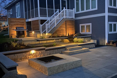 Inspiration for a mid-sized backyard stone patio remodel in Milwaukee with a fire pit