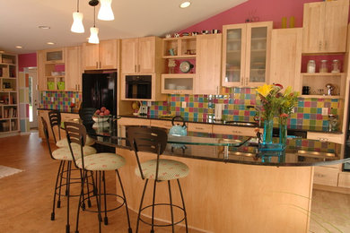 This is an example of a large contemporary single-wall eat-in kitchen in DC Metro with a drop-in sink, flat-panel cabinets, medium wood cabinets, laminate benchtops, multi-coloured splashback, glass tile splashback, black appliances, medium hardwood floors, with island, brown floor and black benchtop.