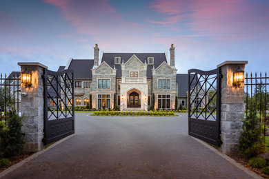 Large tuscan beige three-story stone exterior home photo in Houston