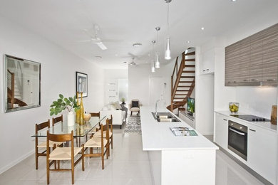 This is an example of a small contemporary kitchen/dining combo in Brisbane with white walls and porcelain floors.