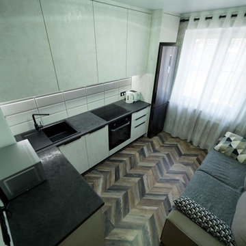 Белая угловая кухня с высокими шкафами и черной столешницей