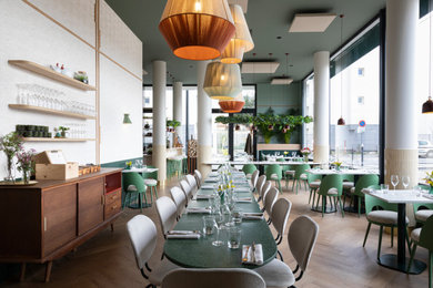 Idée de décoration pour une très grande salle à manger ouverte sur le salon design avec un mur vert, parquet clair et un sol marron.