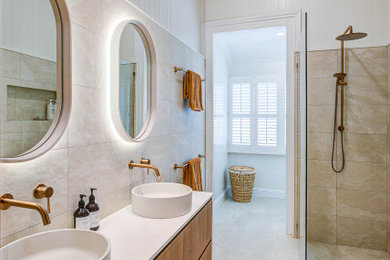 Photo of a mid-sized country master bathroom in Brisbane with furniture-like cabinets, medium wood cabinets, an open shower, a one-piece toilet, ceramic tile, ceramic floors, a vessel sink, engineered quartz benchtops, an open shower, white benchtops, an enclosed toilet, a double vanity and a built-in vanity.