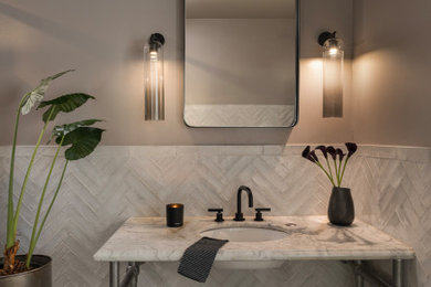 Example of a mid-sized trendy white tile and ceramic tile porcelain tile, gray floor and single-sink toilet room design in San Francisco with marble countertops and a freestanding vanity