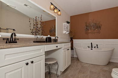Inspiration for a large transitional master bathroom in Chicago with raised-panel cabinets, white cabinets, a freestanding tub, an alcove shower, a two-piece toilet, beige tile, porcelain tile, beige walls, porcelain floors, an integrated sink, onyx benchtops, beige floor, a hinged shower door and beige benchtops.