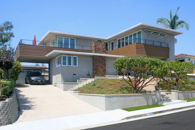 This is an example of a mid-sized midcentury two-storey stucco grey exterior in Orange County with a hip roof.