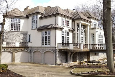 Example of a huge classic white three-story stucco house exterior design in Chicago with a hip roof and a tile roof