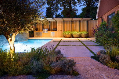 Design ideas for a large contemporary back partial sun garden in London with natural stone paving.