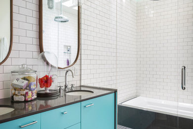Design ideas for a large scandinavian master bathroom in New York with flat-panel cabinets, turquoise cabinets, white tile, subway tile, white walls, an undermount sink, a hinged shower door, black benchtops, an alcove tub, an alcove shower, a two-piece toilet, ceramic floors, solid surface benchtops and grey floor.