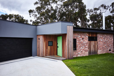 Inspiration för ett mellanstort funkis grått hus, med allt i ett plan och tegel