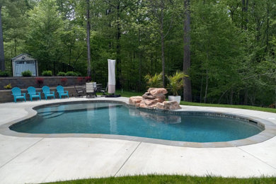 Inspiration för en mellanstor vintage anpassad pool på baksidan av huset, med betongplatta