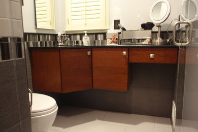 Inspiration for a small contemporary 3/4 multicolored tile and ceramic tile porcelain tile alcove shower remodel in Philadelphia with an undermount sink, flat-panel cabinets, medium tone wood cabinets, granite countertops, a wall-mount toilet and gray walls