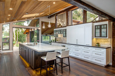 Kitchen - transitional galley dark wood floor, brown floor, exposed beam, vaulted ceiling and wood ceiling kitchen idea in San Diego with an undermount sink, shaker cabinets, white cabinets, white backsplash, paneled appliances, an island and gray countertops