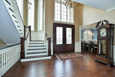 Mid-sized traditional foyer in Other with beige walls, dark hardwood floors, a double front door and a dark wood front door.
