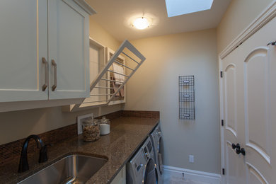Example of a transitional ceramic tile laundry room design in Calgary with an undermount sink, shaker cabinets, white cabinets, quartz countertops, beige walls and a side-by-side washer/dryer