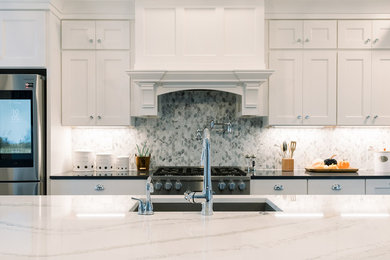 Kitchen - large cottage vinyl floor and brown floor kitchen idea in Cincinnati with shaker cabinets, white cabinets, quartz countertops, multicolored backsplash, stone tile backsplash, stainless steel appliances and an island