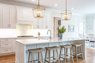 Huge minimalist l-shaped medium tone wood floor open concept kitchen photo in Richmond with an undermount sink, white cabinets, quartzite countertops, white backsplash, stainless steel appliances, an island and white countertops