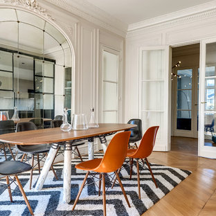 Exemple d'une salle à manger tendance fermée et de taille moyenne avec un mur blanc, un sol en bois brun et aucune cheminée.