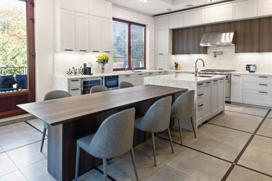 Large transitional u-shaped porcelain tile, gray floor and vaulted ceiling eat-in kitchen photo in New York with an undermount sink, recessed-panel cabinets, gray cabinets, quartz countertops, white backsplash, quartz backsplash, paneled appliances, an island and white countertops