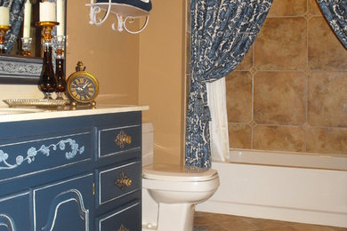 Inspiration for a large timeless 3/4 beige tile and ceramic tile ceramic tile tub/shower combo remodel in Other with blue cabinets, a one-piece toilet and beige walls
