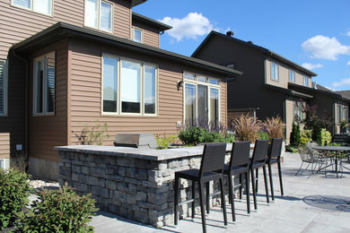 Inspiration for a large modern backyard patio in Ottawa with brick pavers.