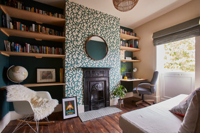 Inspiration for a medium sized retro study in Sussex with green walls, dark hardwood flooring, a standard fireplace, a built-in desk, brown floors, wallpapered walls and a chimney breast.