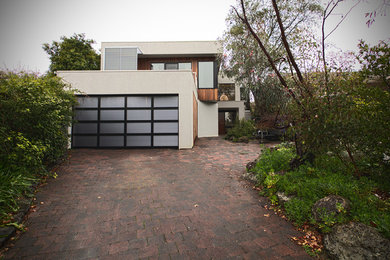 Photo of a large modern two-storey white exterior in Melbourne with wood siding.