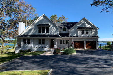 Inspiration for a white two-story concrete fiberboard and clapboard exterior home remodel in New York with a shingle roof and a gray roof