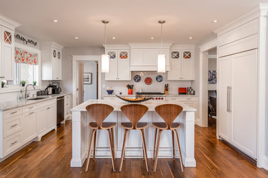 Open concept kitchen - large traditional medium tone wood floor open concept kitchen idea in Toronto with an undermount sink, white cabinets, marble countertops, white backsplash, ceramic backsplash, stainless steel appliances and an island