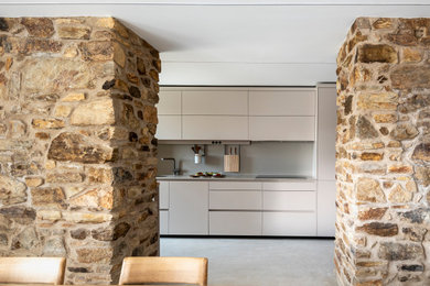 Una cocina lineal semiabierta en una vivienda antigua rehabilitada
