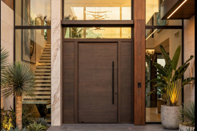 Pivot front door - large modern travertine floor pivot front door idea in Miami with a medium wood front door