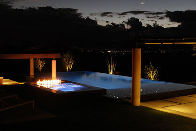 Large trendy backyard concrete and custom-shaped infinity pool fountain photo in Phoenix