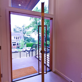 Inspiration for a mid-sized modern concrete floor entryway remodel in Seattle with white walls and a medium wood front door